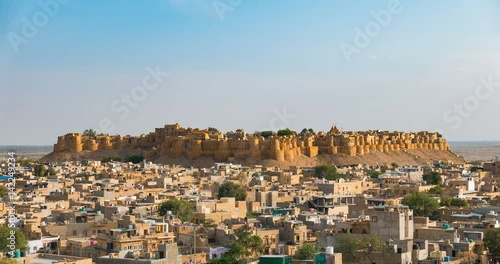 Jaisalmer cityscape from sunset to twilight, time lapse. The majestic fort dominating the desert city like a sand castle. Travel destination in Rajasthan, India.