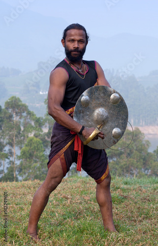 Indian fighter with urumi performing Kalaripayattu marital art demonstration in Kerala, India photo