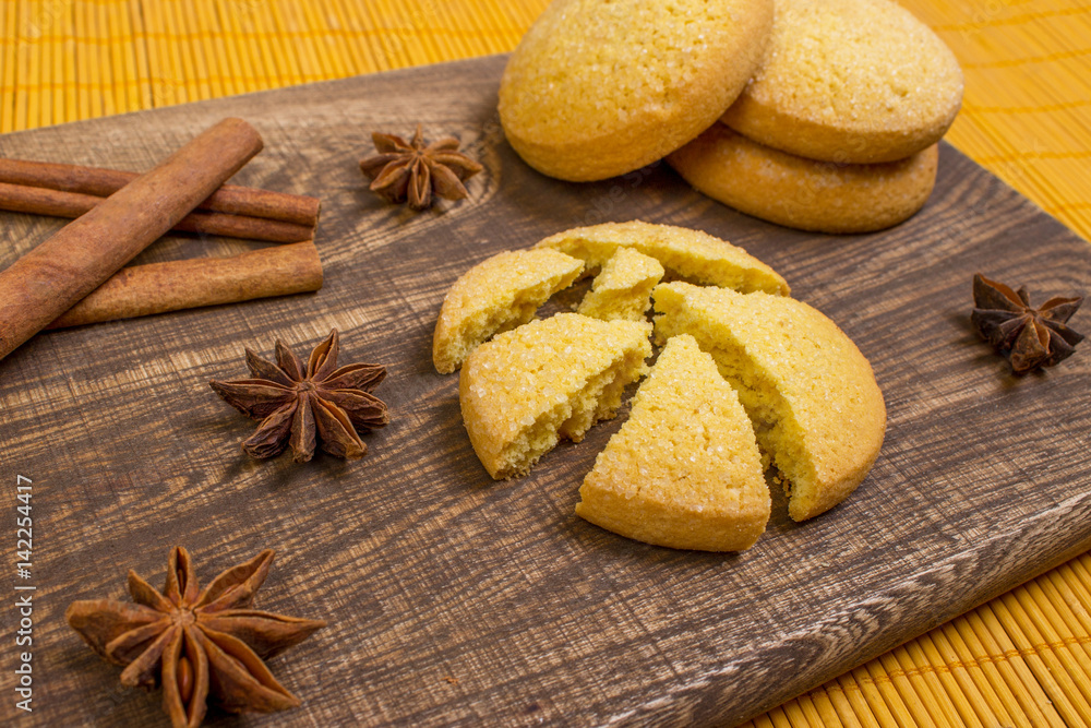 Cookies on the board with spices, cinnamon, star anise. Bamboo canvas.
