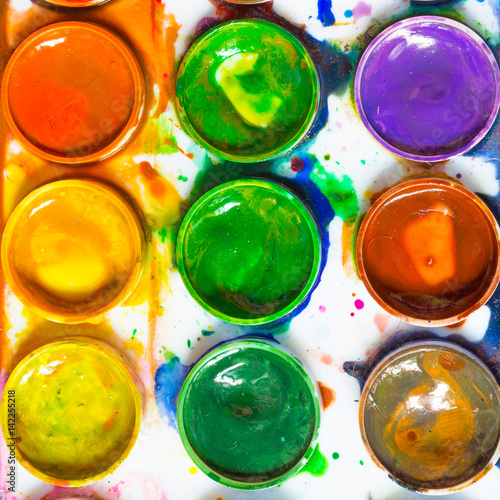 Artistic paint brushes and water color on a dark background