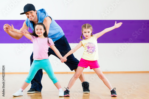 Dance teacher giving kids Zumba dancing class