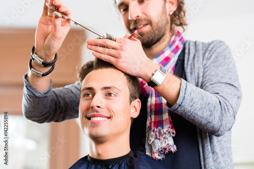 Friseur schneidet Mann die Haare im Friseursalon 