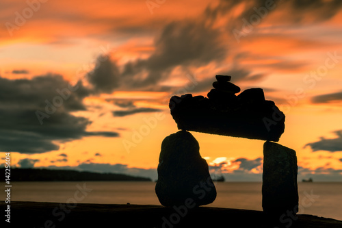rocks balance on beach with sunset clouds sky backgrounds