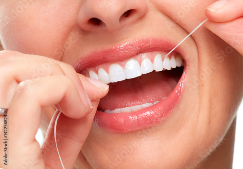 woman smile with tooth floss