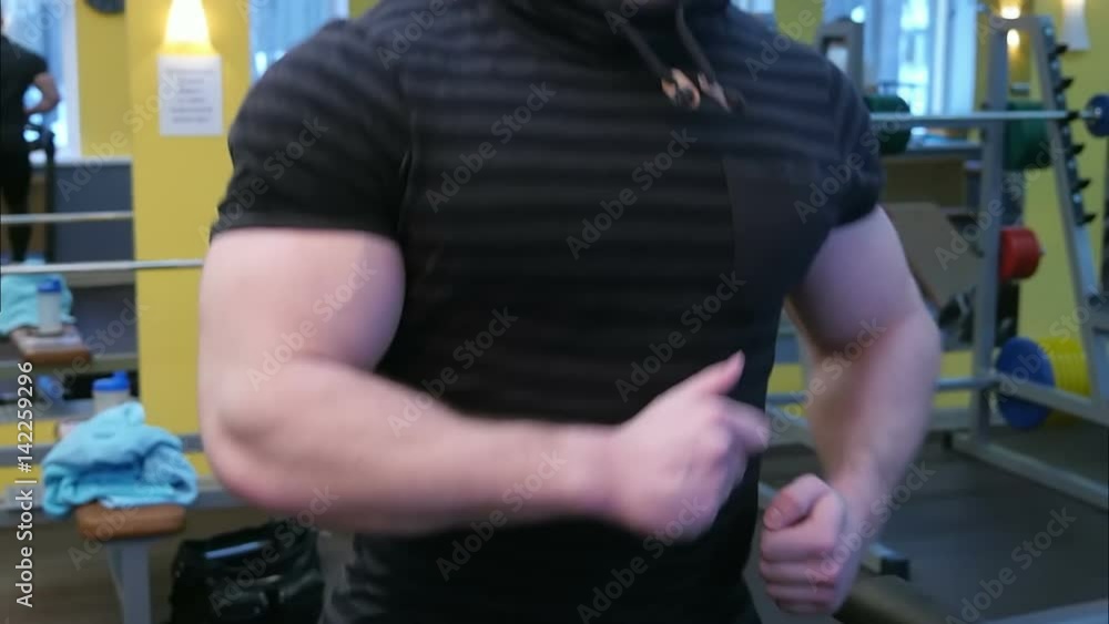 Athletic strong man running on the track in gym Athletic strong man running on the track in gym