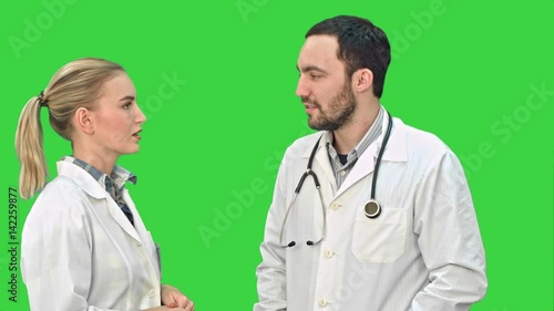Two medical professionals discuss with a patient on a Green Screen, Chroma Key.