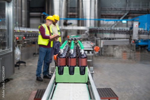 Wallpaper Mural Two factory workers monitoring cold drink bottles  Torontodigital.ca