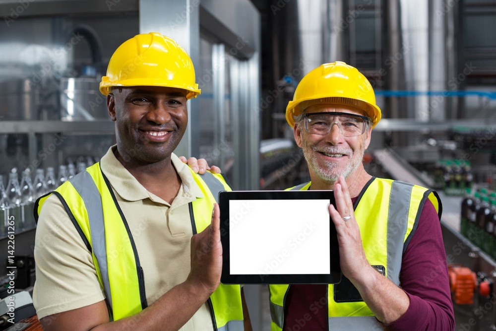 Portrait of factory workers holding digital tablet in the plant Portrait of factory workers holding digital tablet in the plant