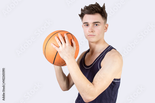 Caucasian teenage boy holding a basketball isolated