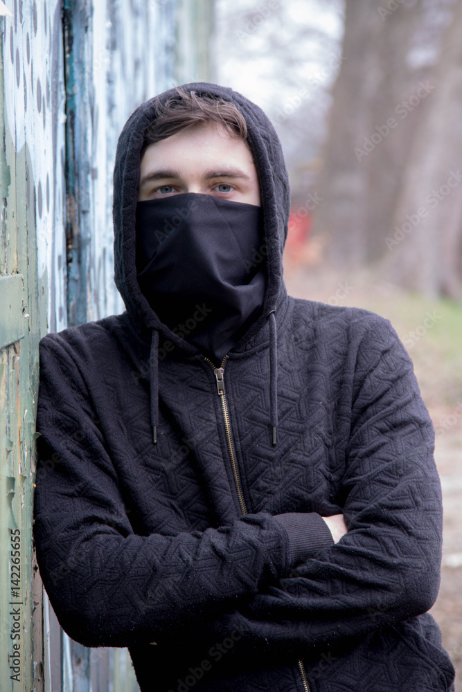 Teenage boy with his face hidden by a mask Teenage boy with his face hidden by a mask