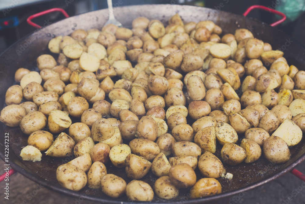 Roasted potatoes cooked in metal cauldron pot Roasted potatoes cooked in metal cauldron pot
