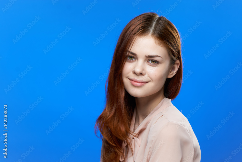 red-haired woman on blue background looking at camera red-haired woman on blue background looking at camera