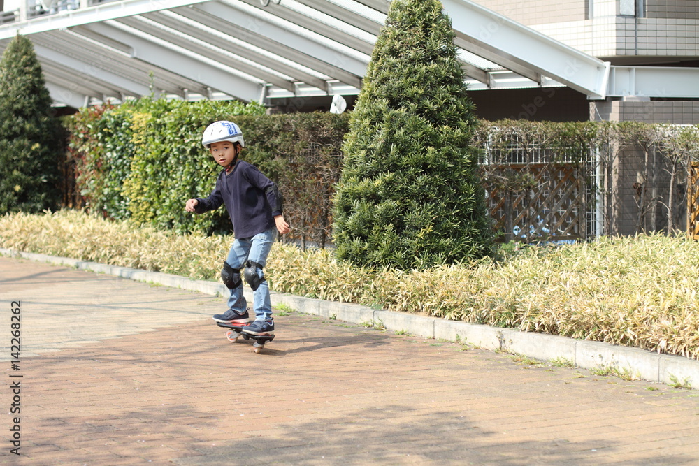 Obraz premium Japanese boy riding on a casterboard (first grade at elementary school)