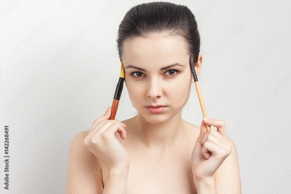 Fototapeta premium beautiful woman holding makeup brushes