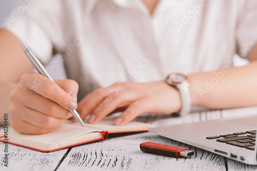 Sexy business woman or secretary with notebook computer pc wearing white suit