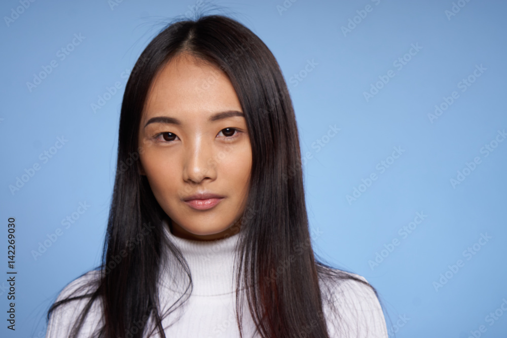 woman with Asian appearance on a blue background woman with Asian appearance on a blue background