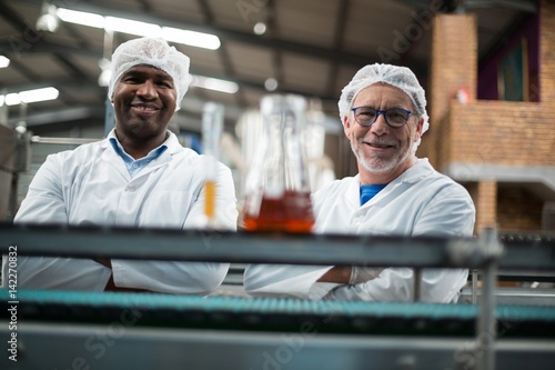 Portrait of two factory engineers standing with arms crossed