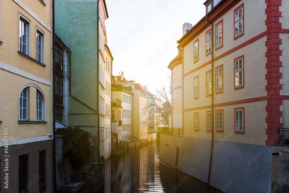 Beautiful view of a street with old water mill in a canal in center of Prague at sunrise. Czechia