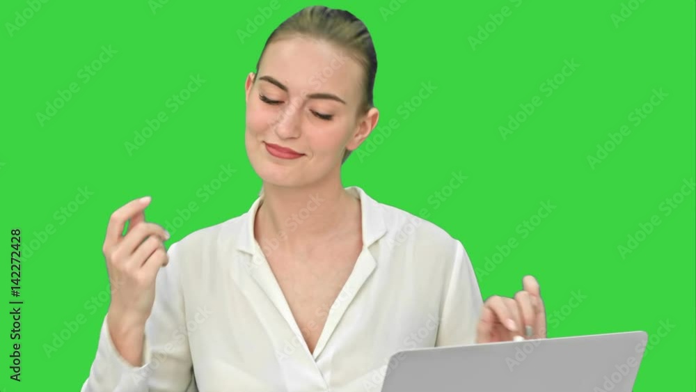 Businesswoman in a good mood dance, sitting on the desk with laptop, and answer a phone call on a Green Screen, Chroma Key.