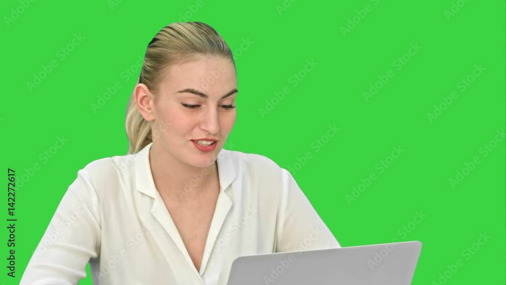 Young businesswoman talking with partner online, using laptop computer on a Green Screen, Chroma Key. Young businesswoman talking with partner online, using laptop computer on a Green Screen, Chroma Key.