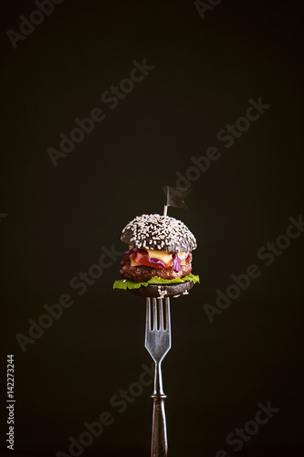 Obraz na płótnie Black mini burger on the fork