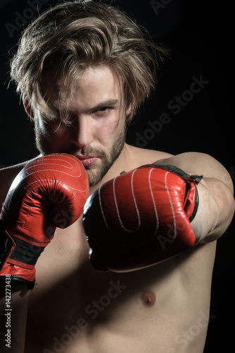 Boxing man ready to fight. Workout, muscle, strength and power. Caucasian handsome man exercising boxing in silhouette studio on black background © Tverdokhlib