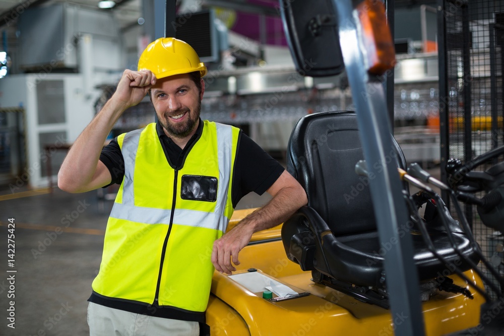 Portrait of smiling factory worker leaning on forklift Portrait of smiling factory worker leaning on forklift