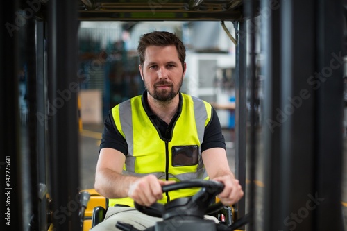Portrait of factory worker driving forklift