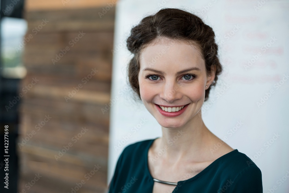 Smiling female business executive standing in office Smiling female business executive standing in office