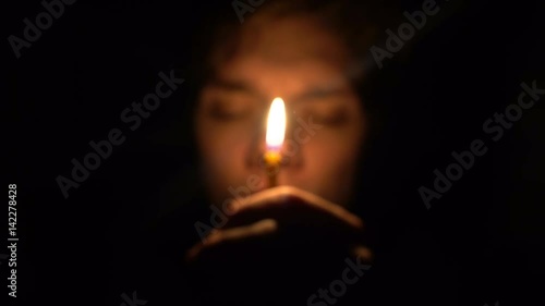 man in dark room hold a candle in front his face