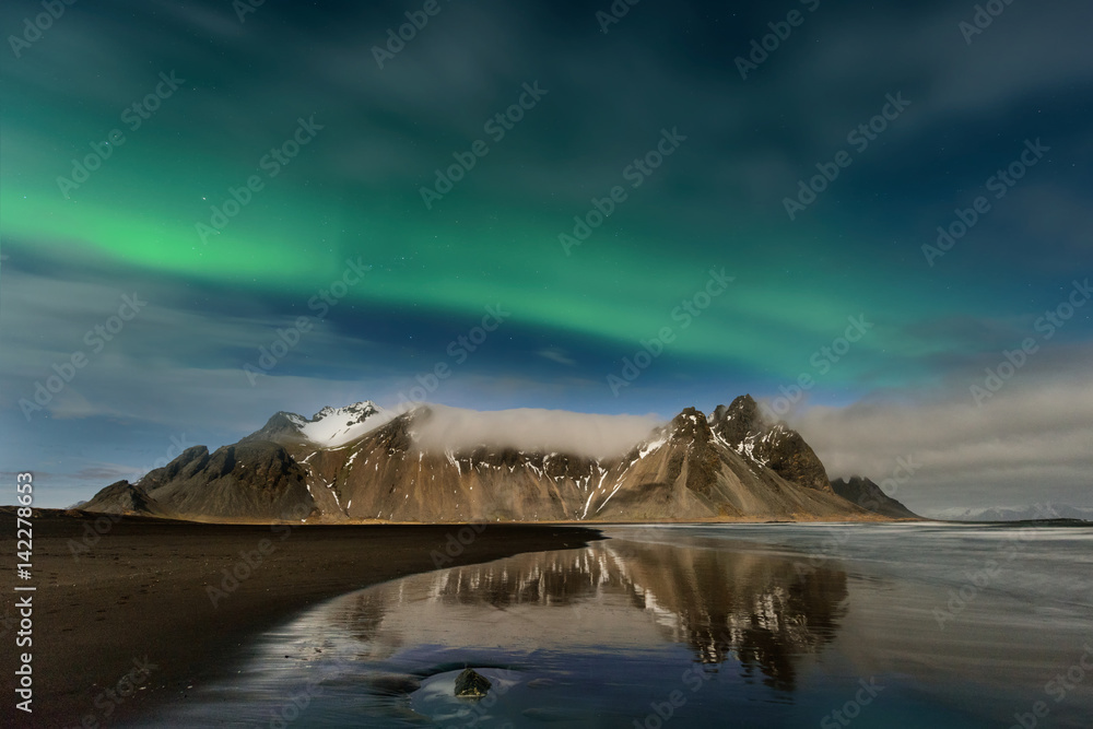 Paisagem nocturna na Islândia. Surpreendente Aurora Boreal na montanha de  Vestrahorn com dunas de areia preta, em Stokksnes, Islândia Stock Photo