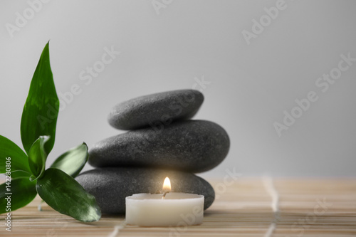 Spa stones with leaves on color background