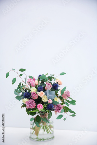 Glass vase with beautiful bouquet on light background