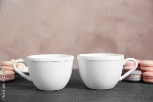 White cups and cookies on grey table