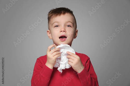 Cute little boy sneezing in...