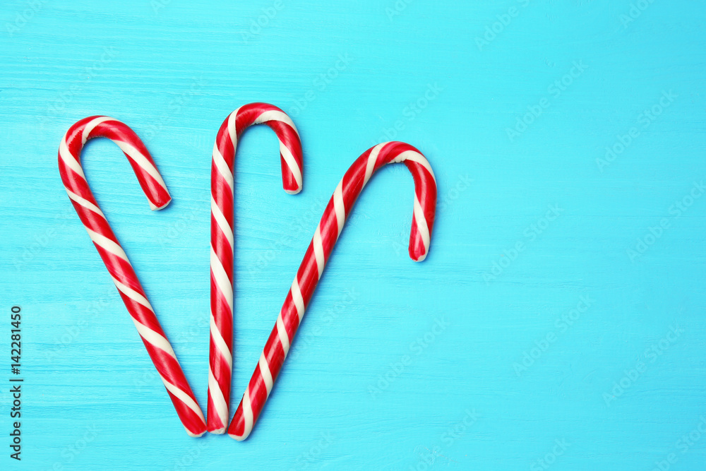 Christmas candy canes on color wooden background Christmas candy canes on color wooden background