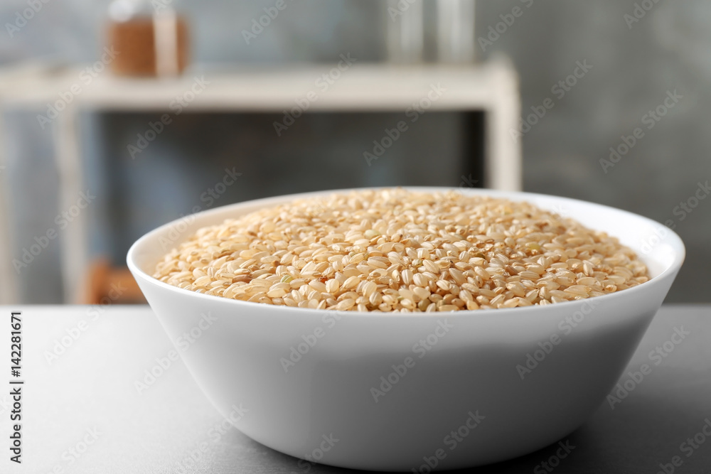 Bowl with raw brown rice on table Bowl with raw brown rice on table