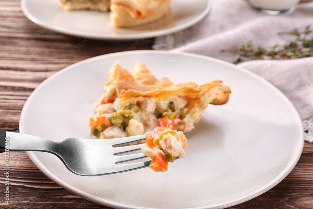 Fork with delicious chicken pot pie over plate Fork with delicious chicken pot pie over plate