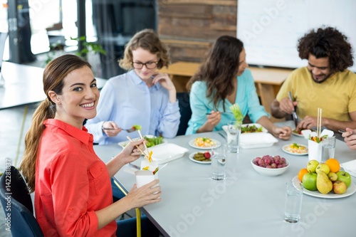 Smiling business executive having meal in office