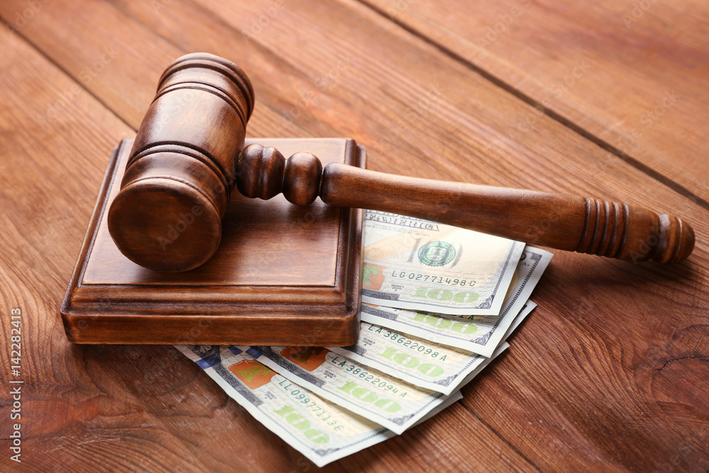 Judge's gavel and dollar banknotes on wooden background Judge's gavel and dollar banknotes on wooden background