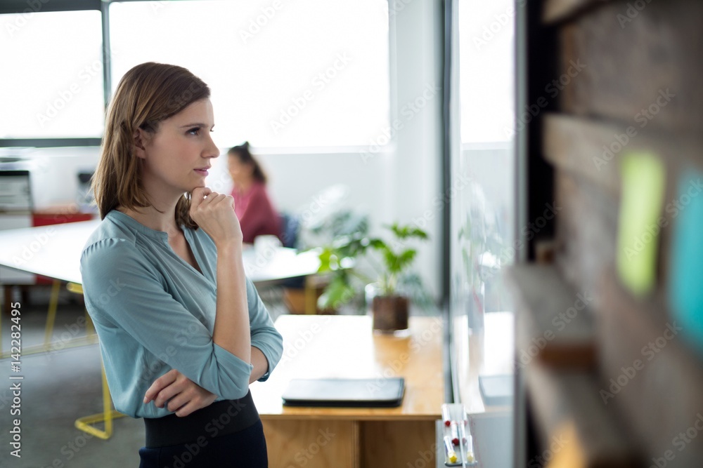 Attentive businesswoman looking at white board Attentive businesswoman looking at white board