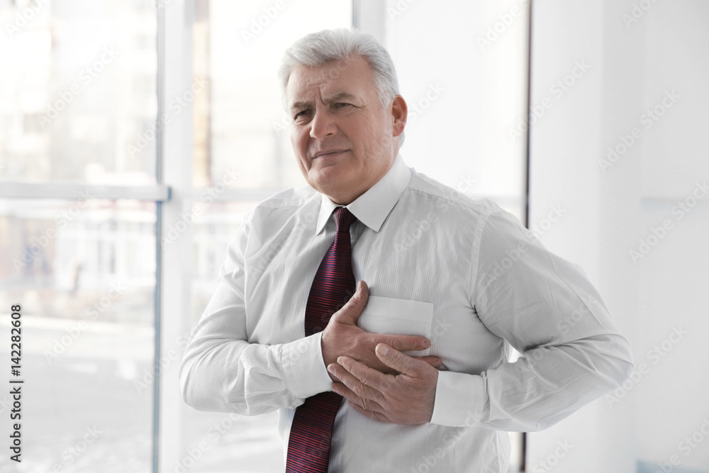 Man with chest pain suffering from heart attack in office Man with chest pain suffering from heart attack in office