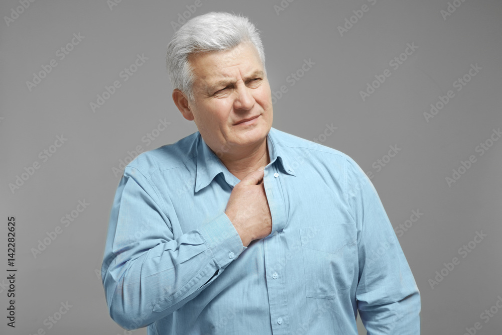 Man with chest pain suffering from heart attack on grey background Man with chest pain suffering from heart attack on grey background