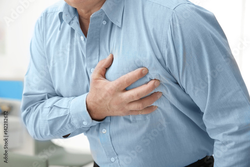 Billede på lærred Man with chest pain suffering from heart attack in office