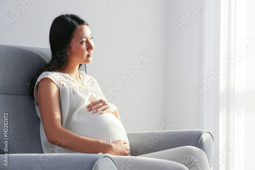 Pregnant Asian woman sittin...