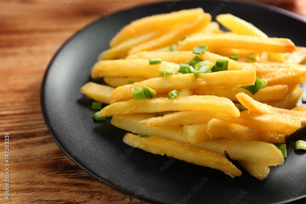Portion of delicious french fries with onion, closeup