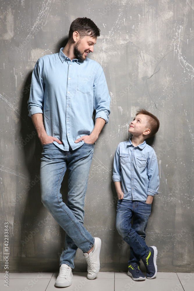 Handsome man with his son near grunge wall