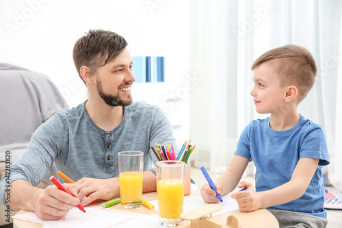 Father and son drawing pictures at home
