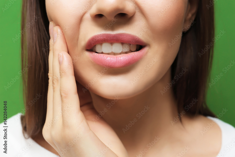 Beautiful young woman suffering from toothache on color background, closeup Beautiful young woman suffering from toothache on color background, closeup