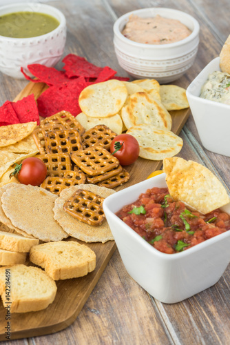 Variety of snacks with dips and salsa.